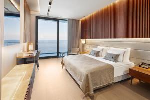 een slaapkamer met een groot bed en een groot raam bij Ricosta Hotel in Rize