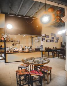 a restaurant with a table and stools in a room at Thaweesuk Heritage Homestay in Phangnga