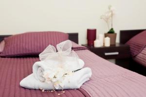 a pile of towels and flowers on a bed at BedRooms Piotrkowska 64 in Łódź