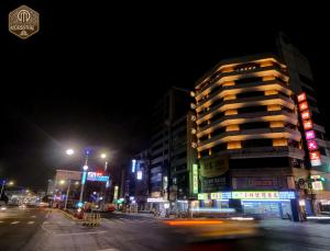 a city street at night with a tall building w obiekcie Modern Inn w mieście Taizhong