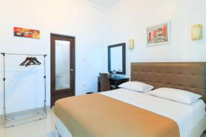 Tempat tidur dalam kamar di Ge JacMart Homestay Makassar