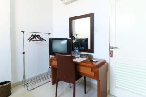 a desk with a television and a mirror in a room at Ge JacMart Homestay Makassar in Makassar