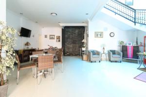 a living room with tables and chairs and a dining room at Ge JacMart Homestay Makassar in Makassar