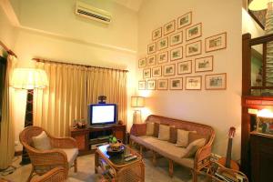 a living room with a couch and a tv at Saku Boutique Homestay in Saraphi