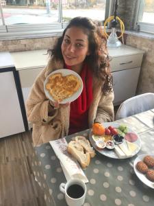 a woman sitting at a table with a plate of food at Anatolia Hotel in Pamukkale