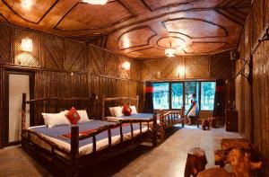 Un dormitorio con dos camas y techo de madera. en Little Yen's Homestay, en Mèo Vạc 118 fotos más