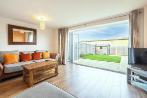 sala de estar con sofá y ventana grande en Modern Townhouse - Sleeps up to 6, en Maidenhead