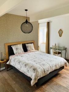 ein Schlafzimmer mit einem großen Bett und einem Tisch in der Unterkunft LE DOMAINE DE COAT ROGAN, La chambre du Jaudy in Pommerit-Jaudy