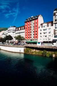 un pont sur une rivière dans une ville avec des bâtiments dans l'établissement Appart'hotel le Pèlerin, à Lourdes