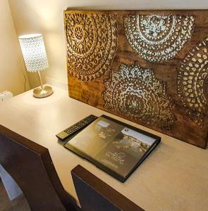 a tablet on a desk with a lamp and a laptop at Hotel Alicia Auray Le Bono in Le Bono