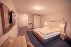 a hotel room with a bed and a table at Eventhotel Moment in Sande