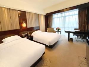 Postel nebo postele na pokoji v ubytování Lv Shou Hotel
