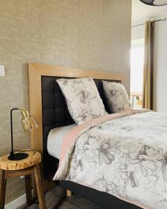 ein Schlafzimmer mit einem Bett und einer Lampe auf einem Tisch in der Unterkunft LE DOMAINE DE COAT ROGAN, La chambre du Jaudy in Pommerit-Jaudy