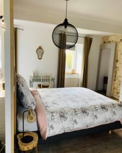 una camera con un grande letto e un tavolo di LE DOMAINE DE COAT ROGAN, La chambre du Jaudy a Pommerit-Jaudy