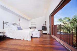 ein Schlafzimmer mit einem Bett und einem Balkon in der Unterkunft Casa Murallas para 6 con piscina en Alcudia cerca de playas in Alcúdia + 65 Fotos