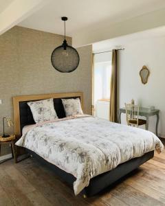 ein Schlafzimmer mit einem großen Bett und einem Tisch in der Unterkunft LE DOMAINE DE COAT ROGAN, La chambre du Jaudy in Pommerit-Jaudy