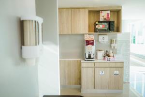 eine kleine Küche mit Mikrowelle und Kaffeemaschine in der Unterkunft วัน บัดเจท เชียงราย สนามบิน One Budget Hotel Chiangrai Airport in Chiang Rai