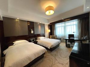 Postel nebo postele na pokoji v ubytování Lv Shou Hotel
