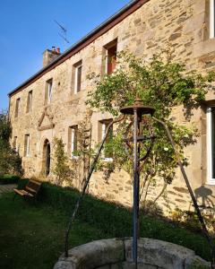 einen Garten vor einem Steingebäude in der Unterkunft LE DOMAINE DE COAT ROGAN, La chambre du Jaudy in Pommerit-Jaudy