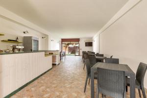 une salle à manger avec des tables et des chaises ainsi qu'une cuisine dans l'établissement Joy Home B&B, à Maruggio