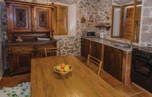 Holiday Home Stari Zoganj في Potomje: مطبخ مع طاولة خشبية مع وعاء من الفواكه عليه