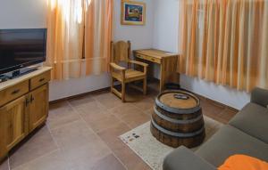 ein Wohnzimmer mit einem Sofa, einem TV und einem Tisch in der Unterkunft Holiday Home Stari Zoganj in Potomje