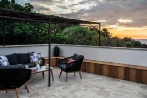 eine Terrasse mit einem Sofa, Stühlen und einem Tisch in der Unterkunft Casa Di Angeli in Corbara