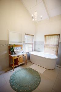 een grote badkamer met een bad en een wastafel bij Leipzig Country House & Winery in Nuy