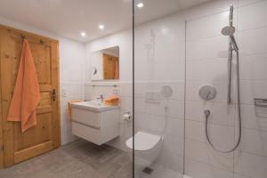 a bathroom with a toilet and a glass shower at Ferienwohnungen Alpentraum - Landhaus am Bächle in Oberstdorf