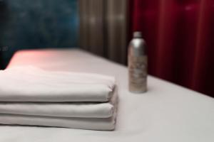 un mucchio di asciugamani seduti su un tavolo con una bottiglia di Hotel Villa a Bisceglie
