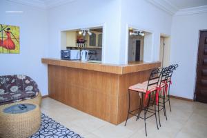 a kitchen with a bar with stools in a room at Résidence Nopeli in Cotonou +115 photos