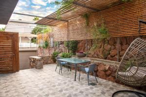 Un patio con mesa y sillas y un muro de piedra. en Modern&Quiet place, en Eilat