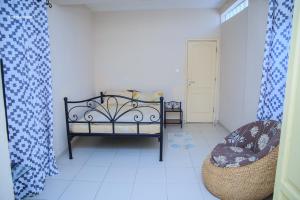 a small room with a bed and a chair at Résidence Nopeli in Cotonou