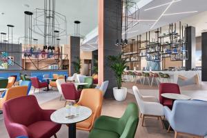 a restaurant with colorful chairs and tables at Hotel Riu Playa Park - 0'0 All Inclusive in Playa de Palma