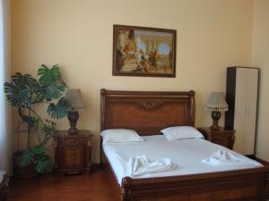 een slaapkamer met een bed en een schilderij aan de muur bij Apartments on Deribasovskaya in Odessa
