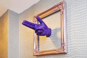 Una mano púrpura apunta a un espejo. en Townhouse PLUS @ Lower Beth Street Stoke, en Etruria