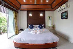 ein Schlafzimmer mit einem großen Bett mit einer Blume darauf in der Unterkunft Vivi Boutique Room Hotel SHA Plus in Rawai Beach