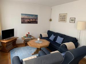 a living room with a blue couch and a table at Frisiastraße 21 in Norderney