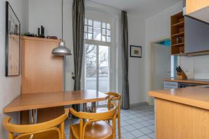 eine Küche mit einem Tisch und Stühlen sowie einem Fenster in der Unterkunft Haus Metropol 2-Raum-Apartment - Nr. 10 in Binz