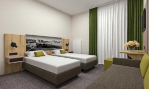 
a hotel room with two beds and a television at Highway Hotel in Herbolzheim
