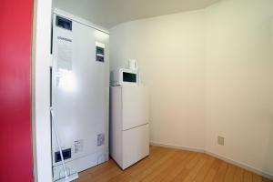 a small room with a refrigerator and a microwave at ETERNITY Tamatsukuri 301 in Osaka