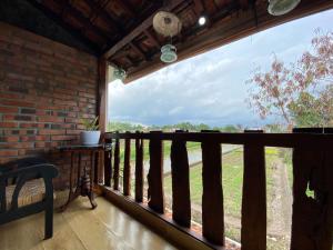 einen Balkon eines Hauses mit Blick auf ein Feld in der Unterkunft Rengganis Homestay in Yogyakarta