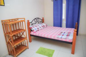 Habitación pequeña con cama y escalera en Résidence Nopeli, en Cotonou