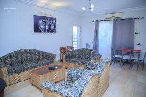 Sala de estar con 2 sofás y mesa en Résidence Nopeli, en Cotonou