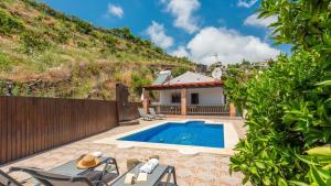 eine Villa mit einem Pool neben einem Hügel in der Unterkunft Villa Belen Torrox by Ruralidays in Torrox