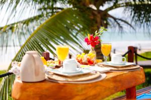 a table with food and drinks on top of it at Sollaris Ecopousada in Japaratinga