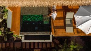 an overhead view of a woman standing next to a swimming pool at Wild Cottages Luxury and Natural - SHA Extra Plus Certified in Lamai