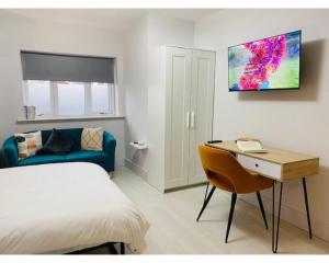 - une chambre avec un lit, un bureau et un canapé dans l'établissement Townhouse PLUS @ Lower Beth Street Stoke, à Etruria
