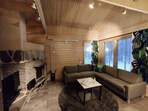 a living room with a couch and a fireplace at Levikaira Apartments - Log Cabins in Levi