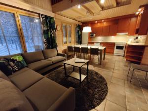 a living room with a couch and a table at Levikaira Apartments - Log Cabins in Levi